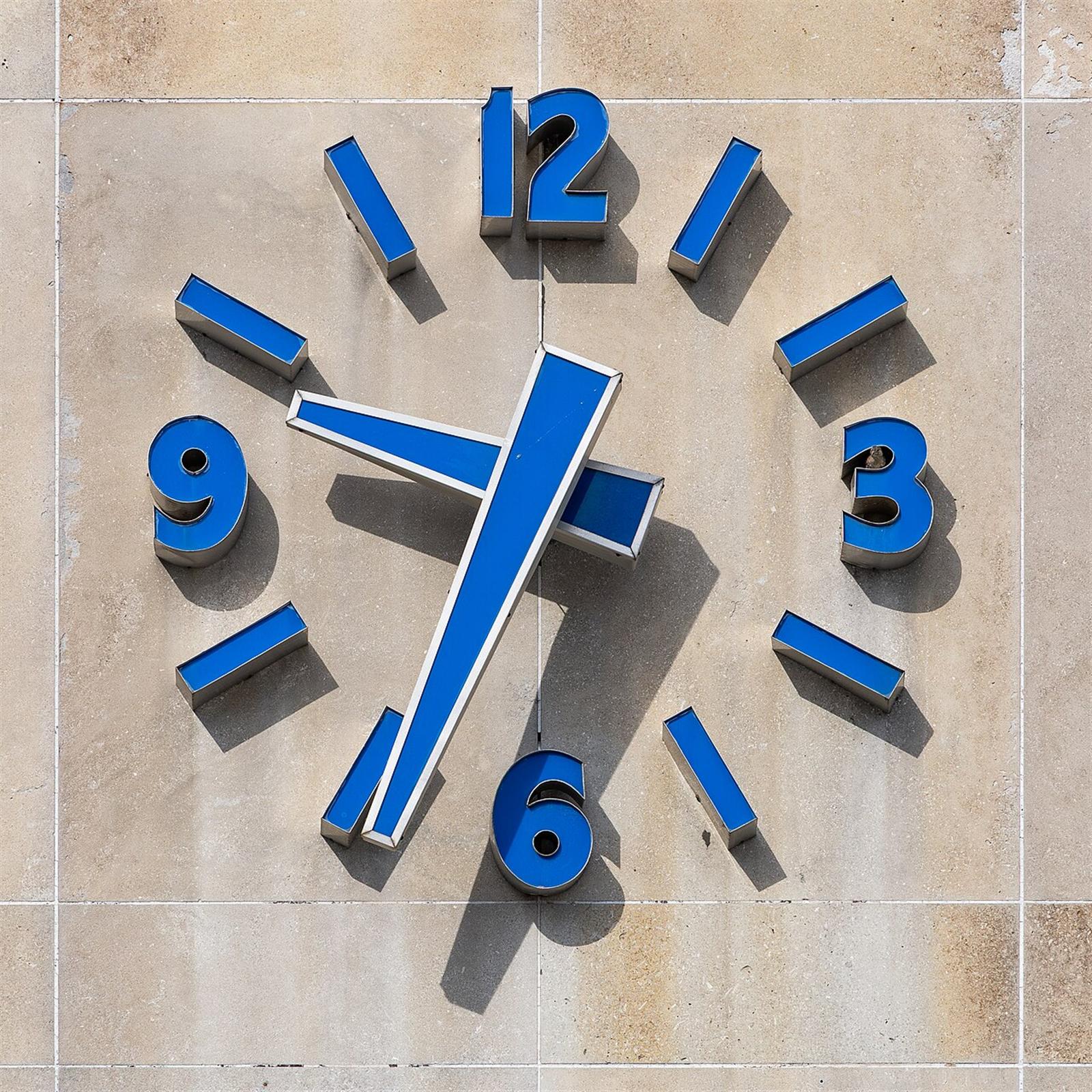 A blue clock face on a stone wall on Dundas Street, London, Ontario